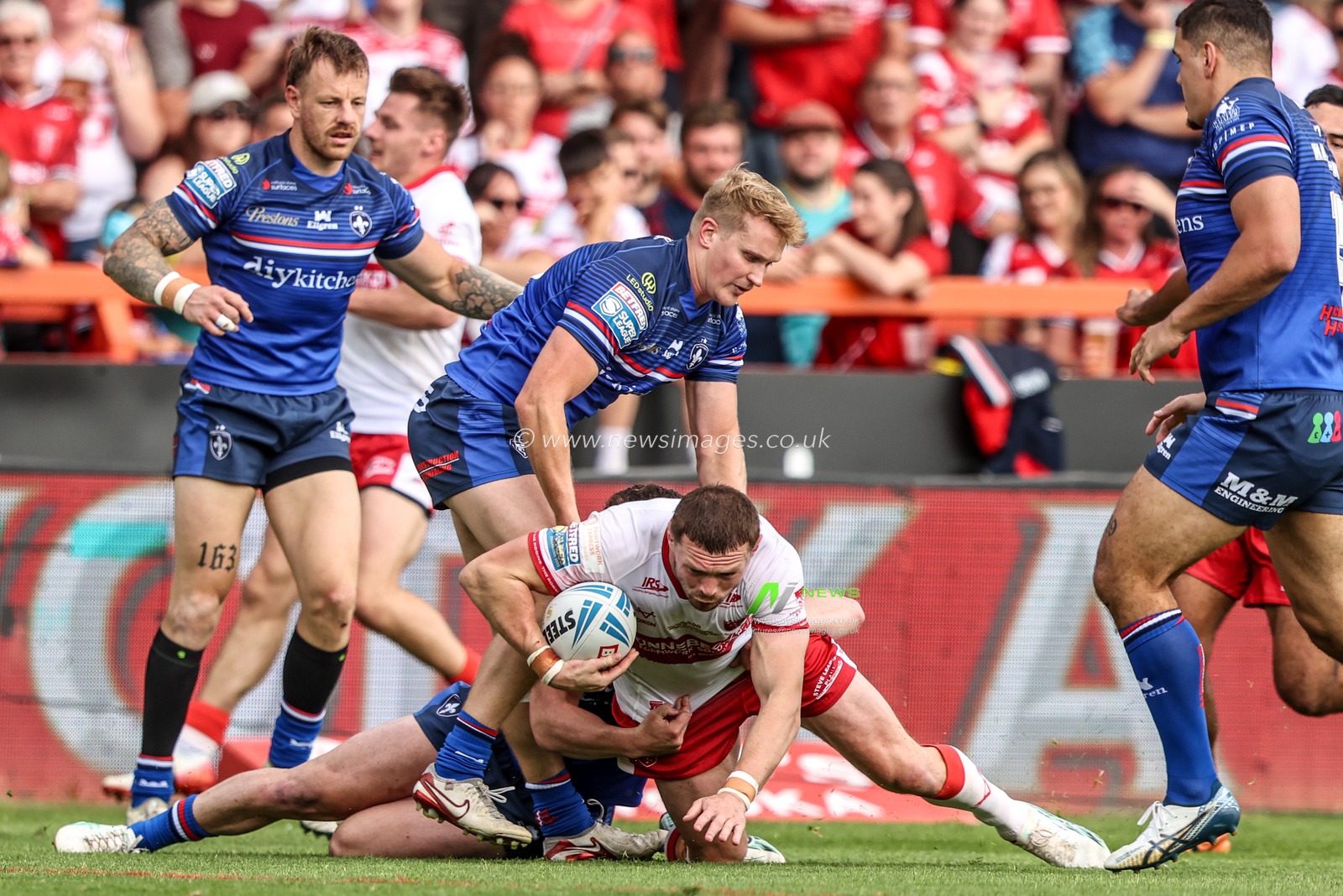 James Batchelor of Hull KR is tackled by Will Tate of Wakefield Trinity and Jake Trueman of Wakefield Trinity during the Betfred Super League round 18 match Hull KR vs Wakefield Trinity at Sewell Group Craven Park, Hull, United Kingdom on 11 July 2026

(Photo by Alfie Cosgrove/News Images)