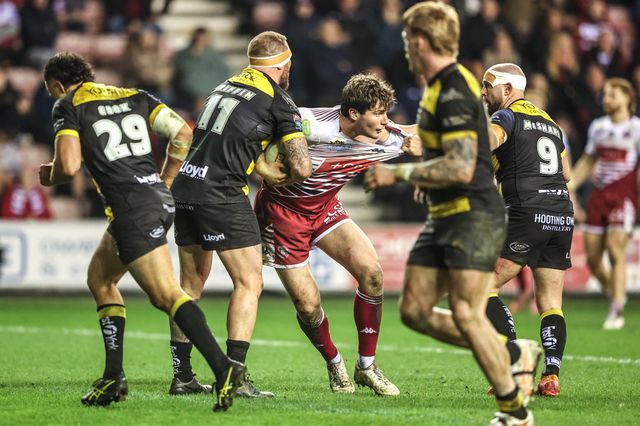 Ethan Havard of Wigan Warriors is tackled by Josh Griffin of York Knights and Paul McShane of York Knights during the Betfred Super League round 5 match Wigan Warriors vs York Knights at The Brick Community Stadium, Wigan, United Kingdom on 19 March 2026

(Photo by Alfie Cosgrove/News Images)
