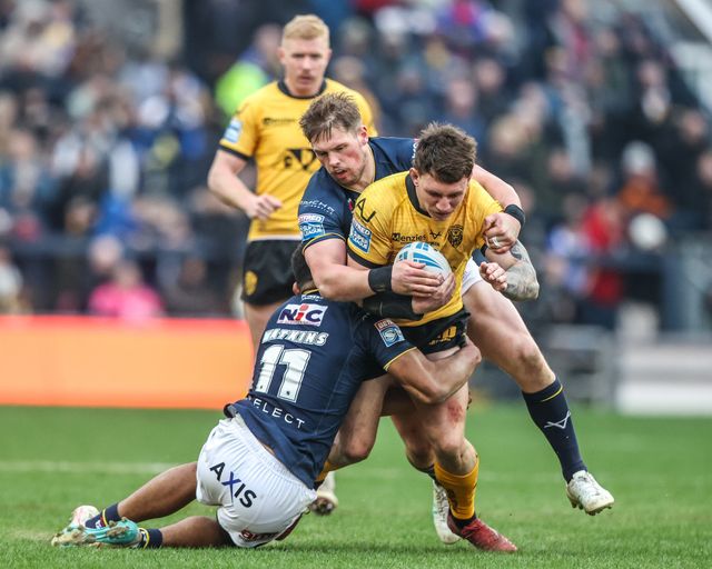 Jordan Lane of Castleford Tigers is tackled by Tom Holroyd of Leeds Rhinos and Kallum Watkins of Leeds Rhinos during the Betfred Super League round 4 match Leeds Rhinos vs Castleford Tigers at AMT Headingley Stadium, Leeds, United Kingdom on 08 March 2026

(Photo by Alfie Cosgrove/News Images)