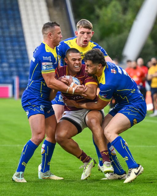 Tui Lolohea of Huddersfield Giants is tackled by Toby King, Josh Drinkwater and Matty Nicholson of Warrington Wolves during the Betfred Super League Round 26 match Huddersfield Giants vs Warrington Wolves at John Smith's Stadium, Huddersfield, United Kingdom, 14th September 2024

(Photo by Craig Thomas/News Images)