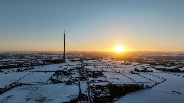 The sun sets over Emley Moor transmitting tower and the snow covered village of Emley as Sub-zero temperatures continue to hamper the north of the United Kingdom; Emley, Huddersfield, United Kingdom, 10th January 2025

(Photo by Mark Cosgrove/News Images)