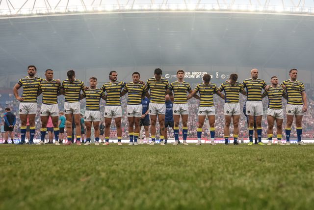 Warrington players arm-in-arm as The Last Post is played as part of Wigans armed forces day during the Betfred Super League round 18 match Wigan Warriors vs Warrington Wolves at The Brick Community Stadium, Wigan, United Kingdom on 10 July 2026

(Photo by Mark Cosgrove/News Images)
