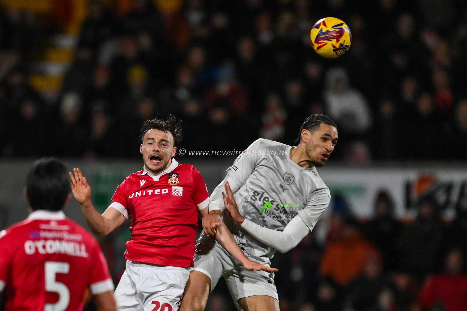Ollie Rathbone of Wrexham and Jon Russell of Barnsley battle for the high ball  ball  during the Sky Bet League 1 match Wrexham vs Barnsley at SToK Cae Ras, Wrexham, United Kingdom, 3rd December 2024

(Photo by Craig Thomas/News Images)