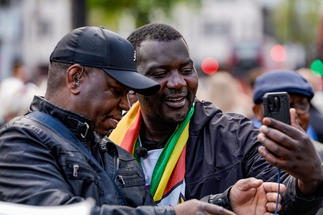 Shepherd Yuda and Makomborero Haruzvishe speak UK-based Zimbabweans gather outside the Zimbabwe Embassy in London on 18 April 2026 to protest the Constitution of Zimbabwe Amendment (No. 3) Bill, which critics say would extend President Mnangagwa’s rule until 2030 and strip citizens of the direct vote for president.

(Photo by Maynard Manyowa/News Images)