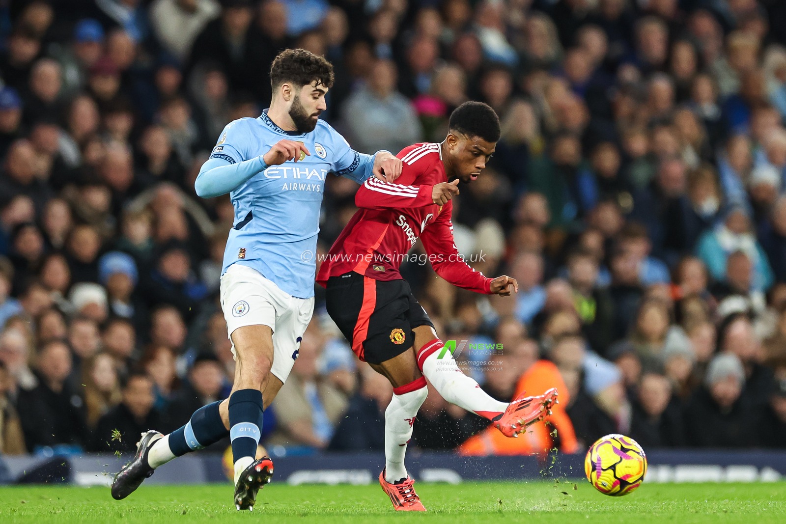 Amad Diallo of Manchester United passes the ball despite pressure from Josko Gvardiol of Manchester City makes a break with the ball during the Premier League match Manchester City vs Manchester United at Etihad Stadium, Manchester, United Kingdom, 15th December 2024

(Photo by Mark Cosgrove/News Images)