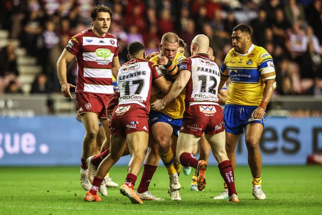 Tom Holroyd of Leeds Rhinos is tackled by ﻿﻿﻿Kruise Leeming of Wigan Warriors and Liam Farrell of Wigan Warriors during the Betfred Super League round 27 match Wigan Warriors vs Leeds Rhinos at The Brick Community Stadium, Wigan, United Kingdom, 19th September 2025

(Photo by Alfie Cosgrove/News Images)