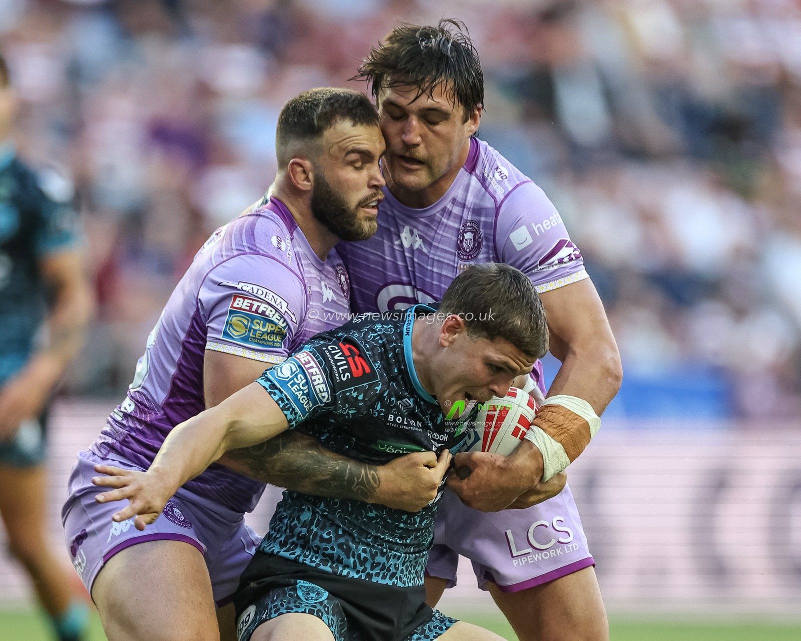 Bailey Hodgson of Leigh Leopards is tackled by Kaide Ellis of Wigan Warriors and Liam Byrne of Wigan Warriors during the Betfred Super League Round 11 match Wigan Warriors vs Leigh Leopards at The Brick Community Stadium, Wigan, United Kingdom, 16th May 2025

(Photo by Mark Cosgrove/News Images)