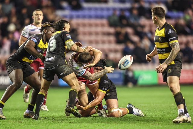 Kaide Ellis of Wigan Warriors passes to Patrick Mago of Wigan Warriors as he is tackled by Xavier Va'a of York Knights during the Betfred Super League round 5 match Wigan Warriors vs York Knights at The Brick Community Stadium, Wigan, United Kingdom on 19 March 2026

(Photo by Alfie Cosgrove/News Images)