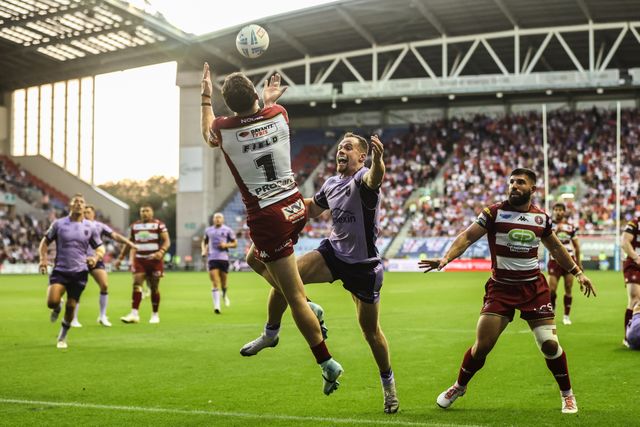 Jai Field of Wigan Warriors jumps up to win the high ball from Joe Burgess of Hull KR during the Betfred Super League round 22 match Wigan Warriors vs Hull KR at The Brick Community Stadium, Wigan, United Kingdom, 15th August 2025

(Photo by Alfie Cosgrove/News Images)