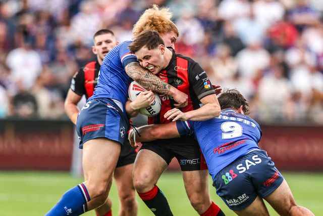 Charlie McKler of Warrington Wolves is tackled by Caius Faatili of Wakefield Trinity and Tyson Smoothy of Wakefield Trinity during the Betfred Super League round 26 match Wakefield Trinity vs Warrington Wolves at DIY Kitchens Stadium, Wakefield, United Kingdom on 05 September 2026

(Photo by Alfie Cosgrove/News Images)