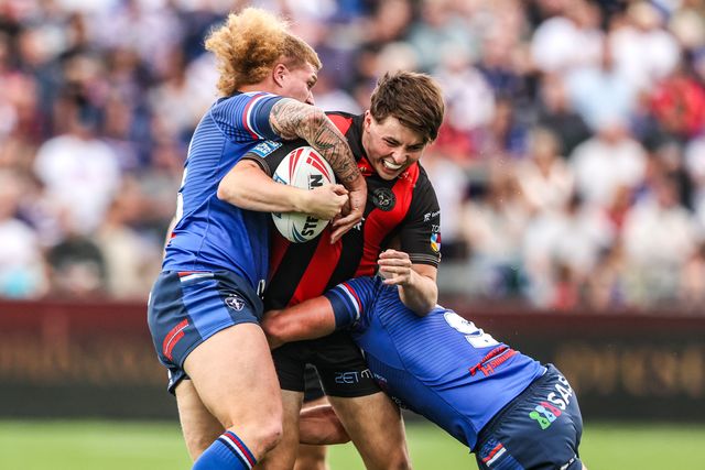 Charlie McKler of Warrington Wolves is tackled by Caius Faatili of Wakefield Trinity and Tyson Smoothy of Wakefield Trinity during the Betfred Super League round 26 match Wakefield Trinity vs Warrington Wolves at DIY Kitchens Stadium, Wakefield, United Kingdom on 05 September 2026

(Photo by Alfie Cosgrove/News Images)