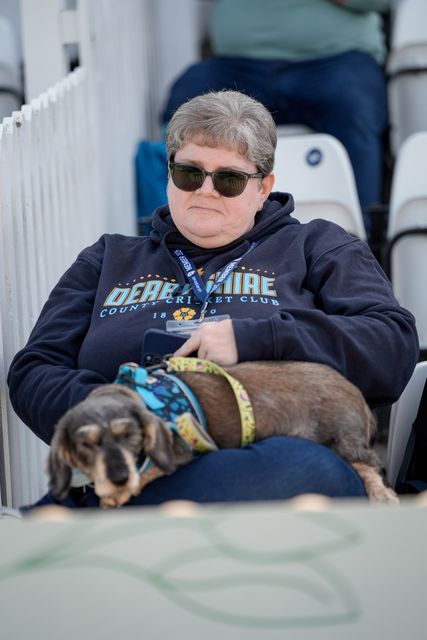 A fan watches the game with her dog during the County Championship Division Two Derbyshire vs Northamptonshire day one match at The Central Co-Op County Ground, Derby, United Kingdom on 08 May 2026

(Photo by Maynard Manyowa/News Images)