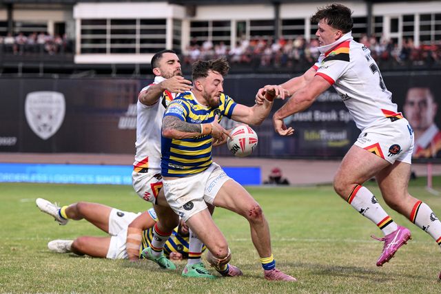 Matty Ashton of Warrington Wolves is challenged by Connor Wynne and Caleb Aekins of Bradford Bulls during the Betfred Super League round 22 match Bradford Bulls vs Warrington Wolves at Odsal Stadium, Bradford, United Kingdom on 08 August 2026

(Photo by Ben Roberts/News Images)