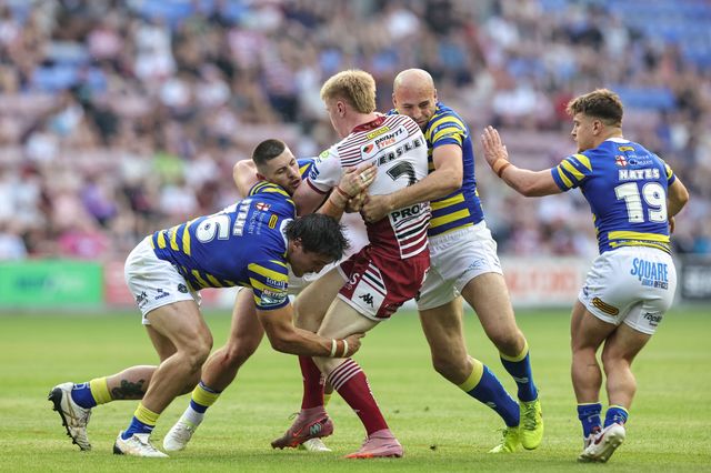Zach Eckersley of Wigan Warriors is tackled by Liam Byrne of Warrington Wolves Danny Walker of Warrington Wolves James Harrison of Warrington Wolves during the Betfred Super League round 18 match Wigan Warriors vs Warrington Wolves at The Brick Community Stadium, Wigan, United Kingdom on 10 July 2026

(Photo by Mark Cosgrove/News Images)