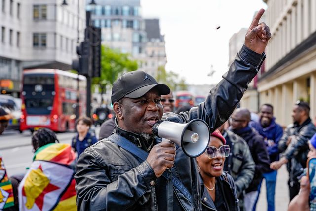 Shepherd Yuda and Makomborero Haruzvishe speak UK-based Zimbabweans gather outside the Zimbabwe Embassy in London on 18 April 2026 to protest the Constitution of Zimbabwe Amendment (No. 3) Bill, which critics say would extend President Mnangagwa’s rule until 2030 and strip citizens of the direct vote for president.

(Photo by Maynard Manyowa/News Images)