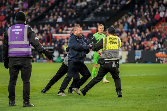 A pitch invader celebrates Yuki Ohashi of Blackburn Rovers scoring to make it 0-2 as security tries to remove him from the pitch during the Sky Bet Championship match Sheffield United vs Blackburn Rovers at Bramall Lane, Sheffield, United Kingdom on 22 April 2026

(Photo by Maynard Manyowa/News Images)