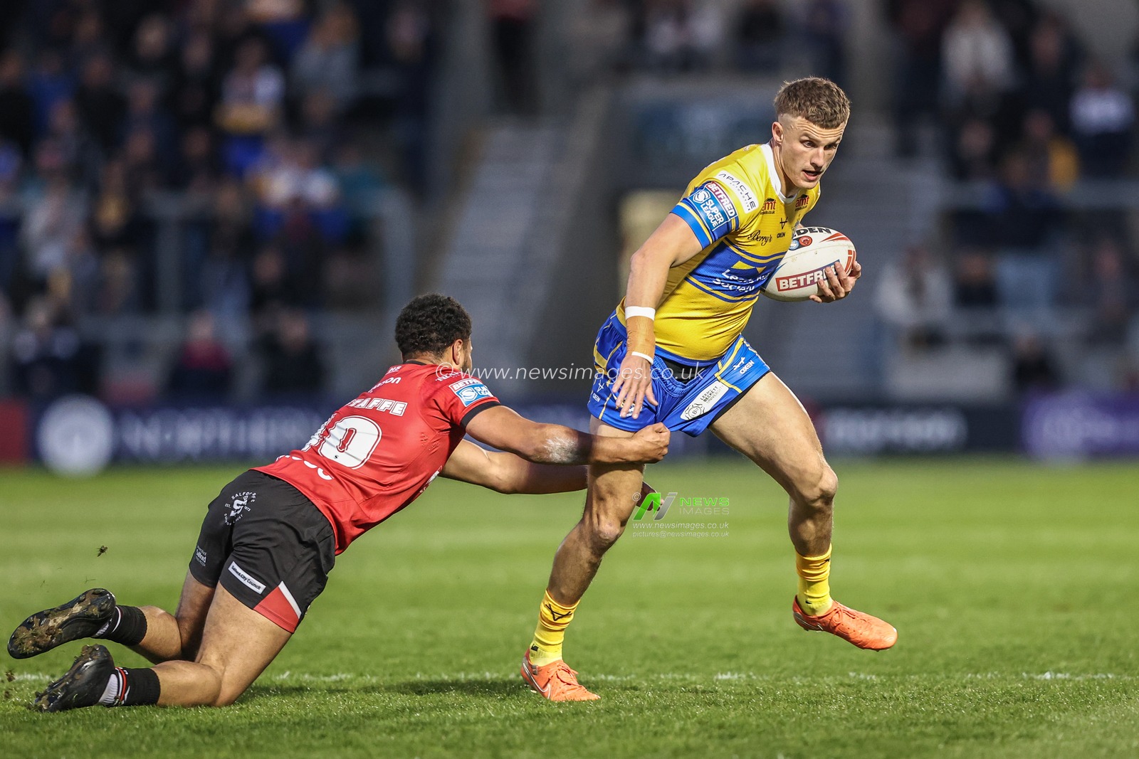 Ash Handley of Leeds Rhinos is tackled during the Betfred Super League match Salford Red Devils vs Leeds Rhinos at Salford Community Stadium, Eccles, United Kingdom, 10th April 2025

(Photo by Alfie Cosgrove/News Images)