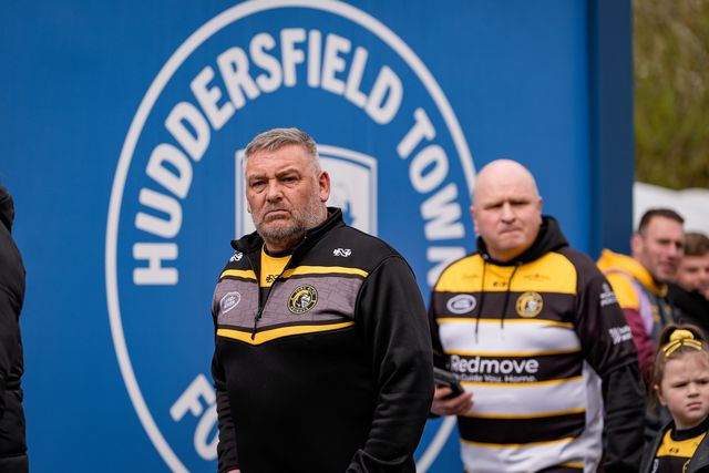 Knights fan walk past a Huddersfield Town FC badge outside the stadium during the Betfred Super League round 7 match Huddersfield Giants vs York Knights at Accu Stadium, Huddersfield, United Kingdom on 04 April 2026

(Photo by Maynard Manyowa/News Images)