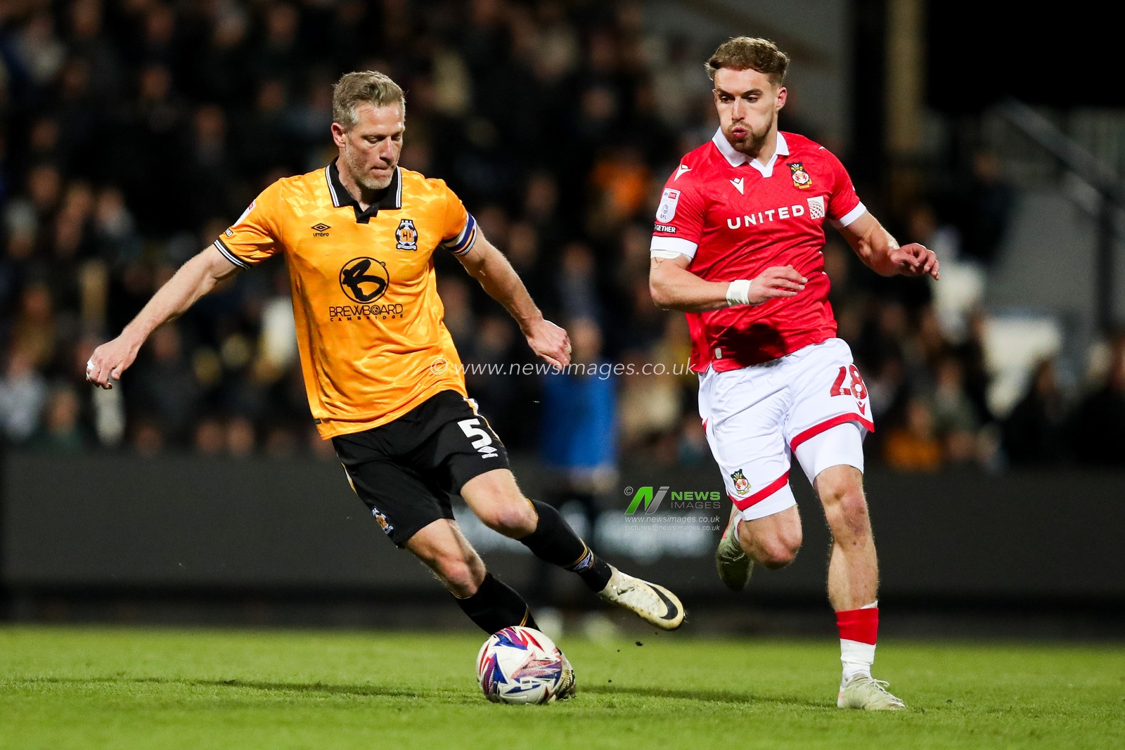 Michael Morrison of Cambridge United is put under pressure by Sam Smith of Wrexham AFC during the Sky Bet League 1 match Cambridge United vs Wrexham at Abbey Stadium, Cambridge, United Kingdom, 1st April 2025

(Photo by Izzy Poles/News Images)