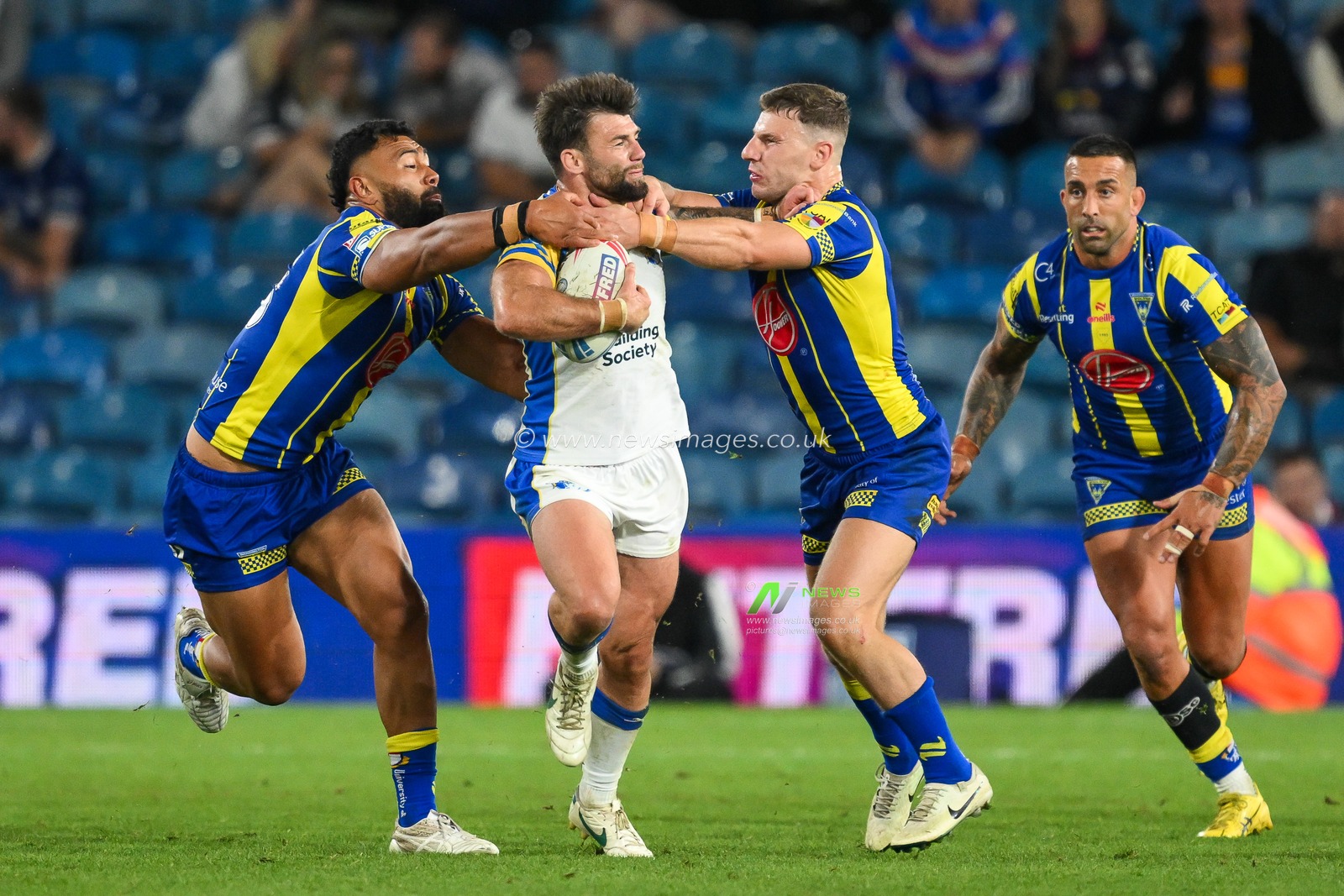 Andy Ackers of Leeds Rhinos is tackled by Zane Musgrove of Warrington Wolves and George Williams of Warrington Wolves during the Magic Weekend match Warrington Wolves vs Leeds Rhinos at Elland Road, Leeds, United Kingdom, 17th August 2024

(Photo by Craig Thomas/News Images)
