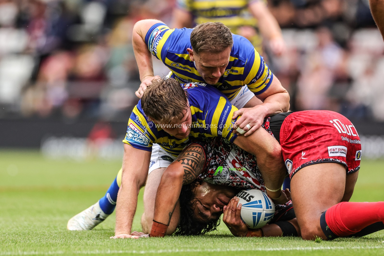 Joe Ofahengaue of Leigh Leopards is tackled by Luke Thomas of Warrington Wolves and Ben Currie of Warrington Wolves during the Betfred Super League round 20 match Leigh Leopards vs Warrington Wolves at Leigh Sports Village, Leigh, United Kingdom on 25 July 2026

(Photo by Alfie Cosgrove/News Images)