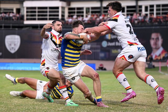 Matty Ashton of Warrington Wolves is challenged by Connor Wynne and Caleb Aekins of Bradford Bulls during the Betfred Super League round 22 match Bradford Bulls vs Warrington Wolves at Odsal Stadium, Bradford, United Kingdom on 08 August 2026

(Photo by Ben Roberts/News Images)