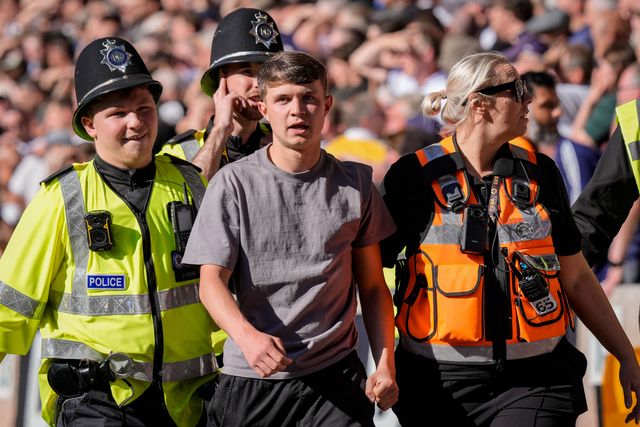 A fan is escorted and ejected from the ground by the police  for attempting to  invade the field of playduring the Premier League match Wolverhampton Wanderers vs Tottenham Hotspur at Molineux, Wolverhampton, United Kingdom on 25 April 2026

(Photo by Maynard Manyowa/News Images)