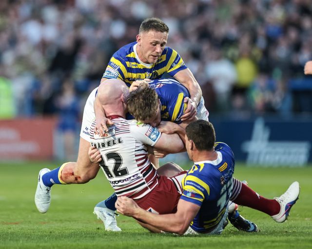 Liam Farrell of Wigan Warriors is tackled by Luke Thomas of Warrington Wolves,Sam Stone of Warrington Wolves and Ben Currie of Warrington Wolves during the Betfred Super League round 9 match Warrington Wolves vs Wigan Warriors at The Halliwell Jones Stadium, Warrington, United Kingdom on 24 April 2026

(Photo by Mark Cosgrove/News Images)