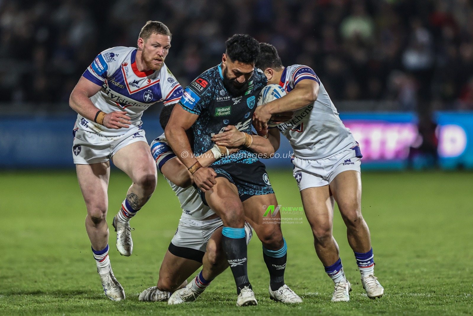 Isaac Liu of Leigh Leopards is tackled by Mason Lino of Wakefield Trinity, Ky Rodwell of Wakefield Trinity and Isaiah Vagana of Wakefield Trinity during the Betfred Challenge Cup Quarter Final match Wakefield Trinity vs Leigh Leopards at DIY Kitchens Stadium, Wakefield, United Kingdom, 4th April 2025

(Photo by Alfie Cosgrove/News Images)