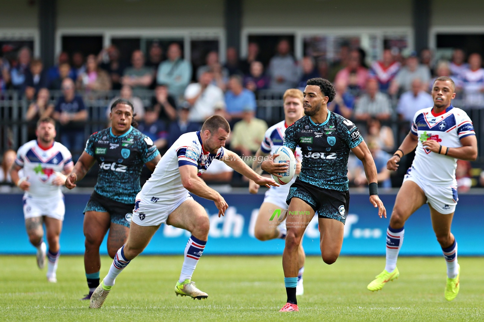 Max Jowitt of Wakefield Trinity tackles Darnell McIntosh of Leigh Leopards before the Betfred Super League Round 14 match Wakefield Trinity vs Leigh Leopards at DIY Kitchens Stadium, Wakefield, United Kingdom, 15th June 2025(Photo by Sam Eaden/News Images)