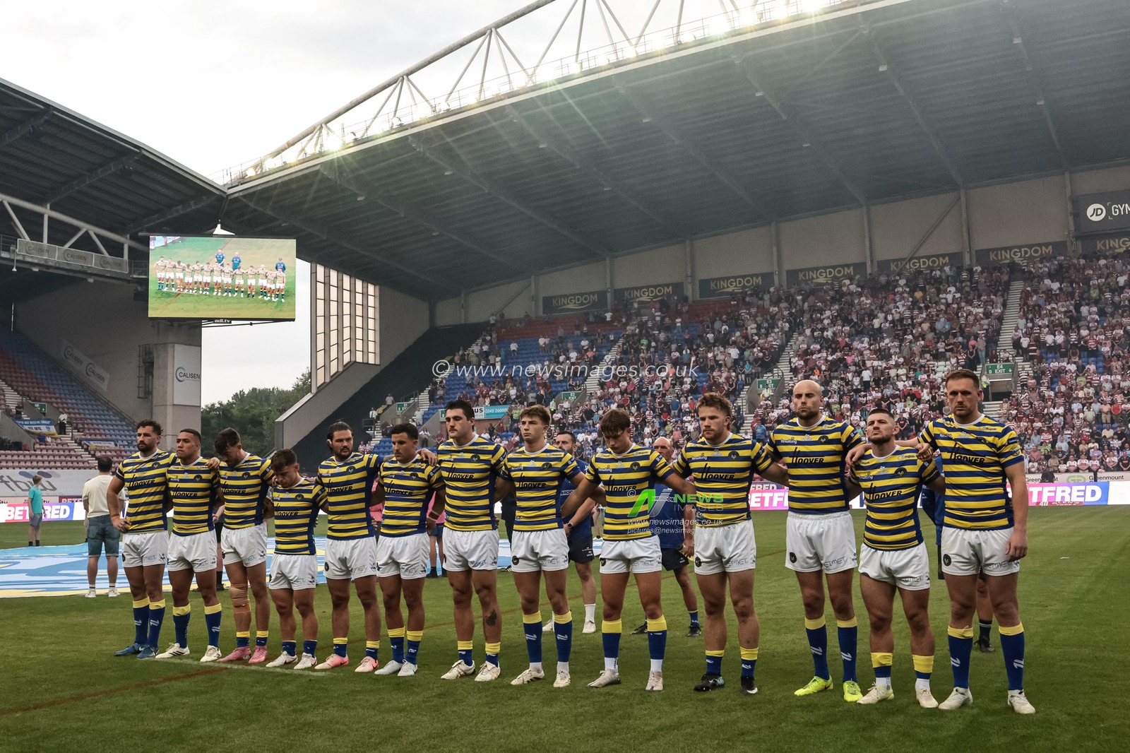 Warrington players arm-in-arm as The Last Post is played as part of Wigans armed forces day during the Betfred Super League round 18 match Wigan Warriors vs Warrington Wolves at The Brick Community Stadium, Wigan, United Kingdom on 10 July 2026

(Photo by Mark Cosgrove/News Images)