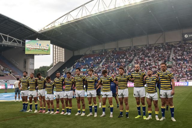 Warrington players arm-in-arm as The Last Post is played as part of Wigans armed forces day during the Betfred Super League round 18 match Wigan Warriors vs Warrington Wolves at The Brick Community Stadium, Wigan, United Kingdom on 10 July 2026

(Photo by Mark Cosgrove/News Images)