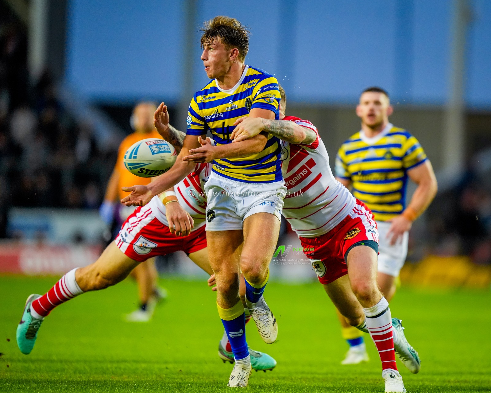 Ewan Irwin of Warrington Wolves breaks with the ball and is tackled by Shane Wright of St Helens R.F.C. and Daryl Clark of St Helens R.F.C. during the Betfred Super League round 14 match St Helens vs Warrington Wolves at The BrewDog Stadium, St Helens, United Kingdom on 11 June 2026

(Photo by Maynard Manyowa/News Images)