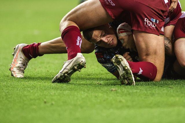 Bailey Hodgson of Leigh Leopards is tackled by Kaide Ellis of Wigan Warriors and Liam Farrell of Wigan Warriors during the Betfred Super League Semi Final 1 match Wigan Warriors vs Leigh Leopards at The Brick Community Stadium, Wigan, United Kingdom, 3rd October 2025

(Photo by Alfie Cosgrove/News Images)