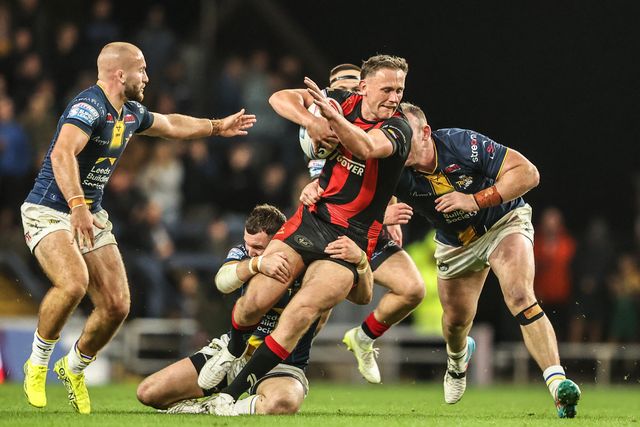 Ben Currie of Warrington Wolves is tackled by Cameron Smith of Leeds Rhinos and Matt Lodge of Leeds Rhinos during the Betfred Super League Play-off Semi-Final match Leeds Rhinos vs Warrington Wolves at AMT Headingley Stadium, Leeds, United Kingdom on 25 September 2026

(Photo by Alfie Cosgrove/News Images)