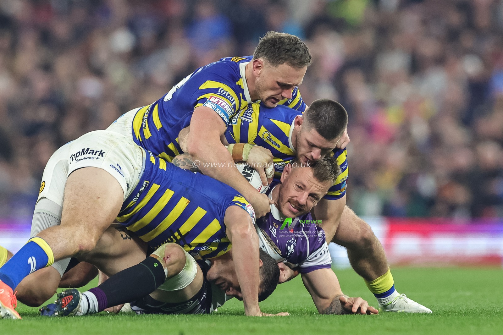 Tom Johnstone of Wakefield Trinity is tackled by Sam Stone of Warrington Wolves Ben Currie of Warrington Wolves and Danny Walker of Warrington Wolves during the Betfred Super League Grand Final match Warrington Wolves vs Wakefield Trinity at Old Trafford, Manchester, United Kingdom on 03 October 2026

(Photo by Mark Cosgrove/News Images)