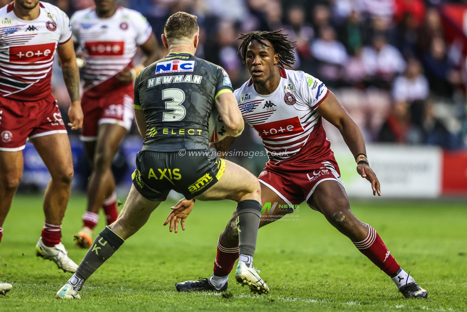 Harry Newman of Leeds Rhinos is tackled by Junior Nsemba of Wigan Warriors during the Betfred Super League round 11 match Wigan Warriors vs Leeds Rhinos at The Brick Community Stadium, Wigan, United Kingdom on 15 May 2026

(Photo by Alfie Cosgrove/News Images)