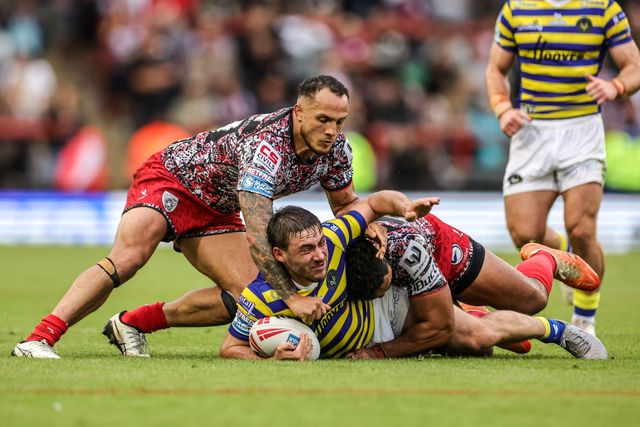 Adam Holroyd of Warrington Wolves is tackled by Liam Horne of Leigh Leopards and Isaac Liu of Leigh Leopards during the Betfred Super League round 20 match Leigh Leopards vs Warrington Wolves at Leigh Sports Village, Leigh, United Kingdom on 25 July 2026

(Photo by Alfie Cosgrove/News Images)