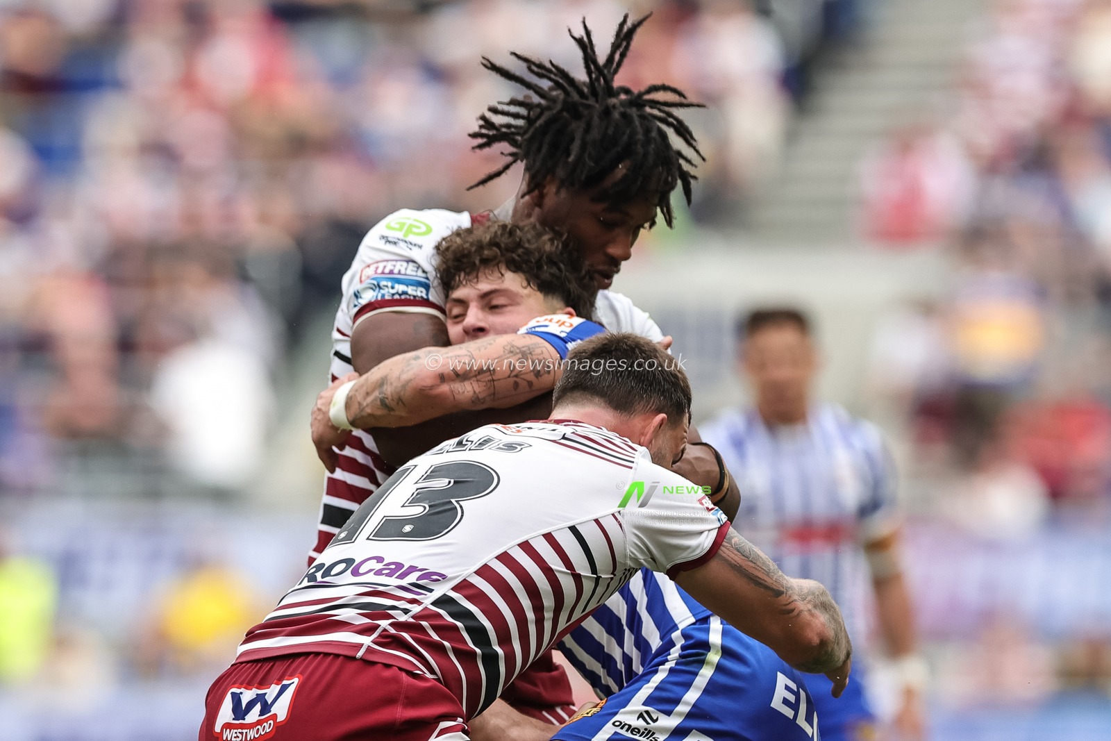 Owen Dagnall of St Helens R.F.C. is tackled by Junior Nsemba and Kaide Ellis of Wigan Warriors during the Betfred Super League Magic Weekend match Wigan Warriors vs St Helens at Hill Dickinson Stadium, Liverpool, United Kingdom on 05 July 2026

(Photo by Mark Cosgrove/News Images)