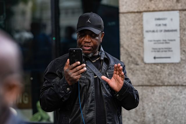 Shepherd Yuda steams live as UK-based Zimbabweans gather outside the Zimbabwe Embassy in London on 18 April 2026 to protest the Constitution of Zimbabwe Amendment (No. 3) Bill, which critics say would extend President Mnangagwa’s rule until 2030 and strip citizens of the direct vote for president.

(Photo by Maynard Manyowa/News Images)