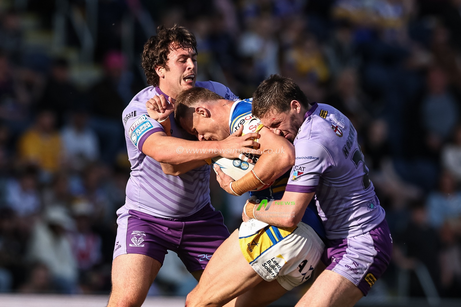 Ash Handley of Leeds Rhinos is tackled by Adam Holroyd of Warrington Wolves during the Betfred Super League Round 14 Leeds Rhinos v Warrington Wolves at Headingley Stadium, Leeds, United Kingdom, 14th June 2025

(Photo by Mark Cosgrove/News Images)